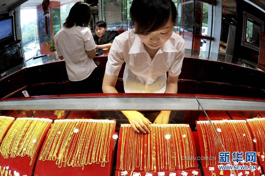 9月26日，浙江義烏一金店工作人員在整理上柜銷售的黃金飾品。隨著國際黃金市場(chǎng)風(fēng)云突變，國內(nèi)金價(jià)26日繼續(xù)大跌。與此同時(shí)，曾經(jīng)高高在上的鉑金價(jià)格也大幅下調(diào)，出現(xiàn)了黃金價(jià)格全面高于鉑金價(jià)格的罕見倒掛現(xiàn)象。26日，上海黃金交易所黃金Au99.95合約收盤價(jià)為每克327.95元，而鉑金Pt99.95合約收盤價(jià)僅為每克326.08元。